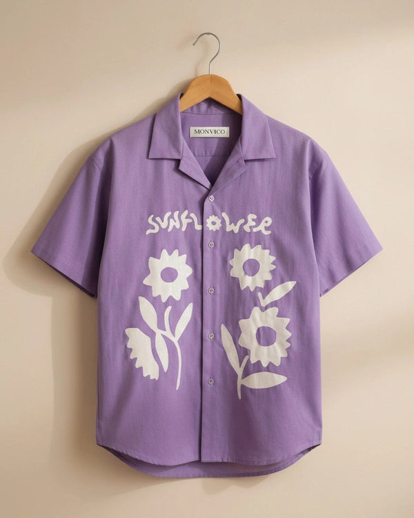 Purple shirt with white floral designs and 'Sunflower' text on a beige background