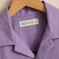 Purple garment with a 'MONVICO' label on a wooden hanger