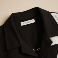 Black shirt with a visible 'MONVICO' label on a beige background
