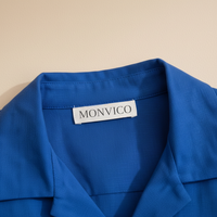 Blue garment with a Monvico label on a beige background