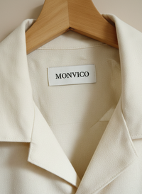 Beige blazer with 'MONVICO' label on a wooden hanger