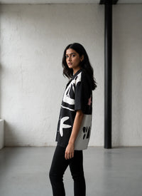 Woman wearing a black and white patterned shirt in an indoor setting