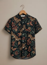Short-sleeve shirt with leopard and floral pattern on a hanger against a beige background