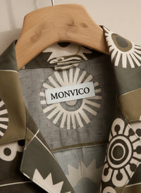 Fabric with geometric patterns and 'MONVICO' label on a wooden hanger