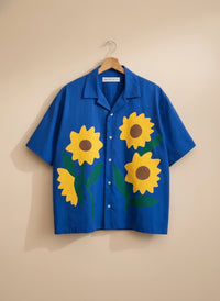 Blue shirt with sunflower designs on a beige background